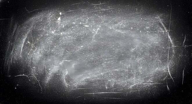 A detailed view of a dark and weathered chalkboard surface filled with various scratches and dust
