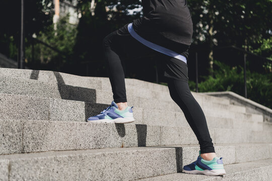 Active woman stairs workout outdoors in the city park wearing sporty shoes and fitness outfit performing a stair climb for cardio training and daily wellness in an urban morning scene