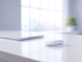 White wireless mouse on clean desk with closed laptop and blurred window background in bright room