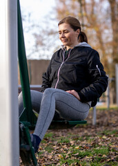 Obraz premium Woman Doing Leg Exercises On The Outdoor Gym Equipment In The Park