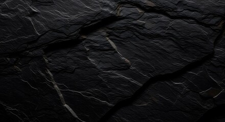 A high resolution close up view of the rough and dark textured surface of natural black slate rock