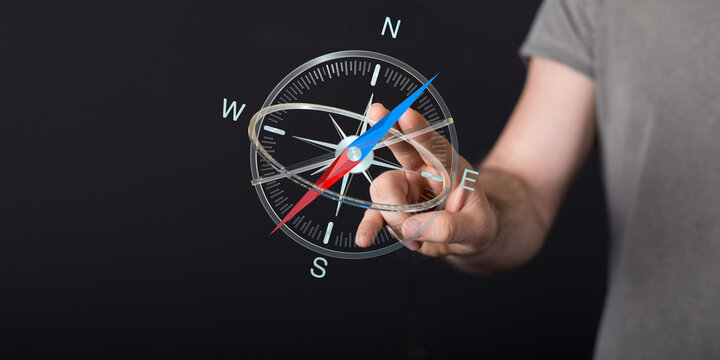 A close-up of a person's hand interacting with a digital compass, representing guidance and direction. Perfect for conce