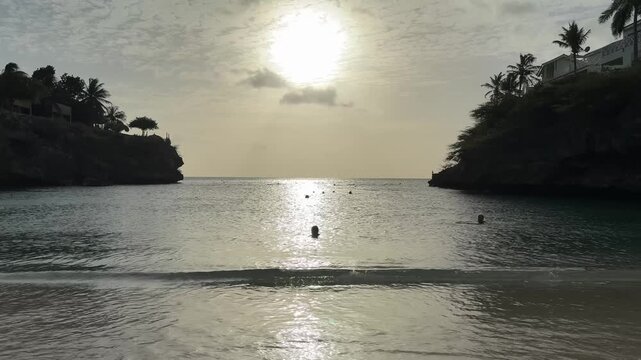 Golden sunset at Playa Lagun, Curacao with swimmers