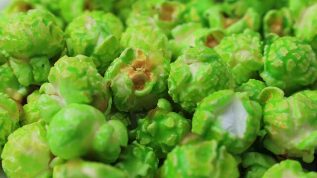 Bright green apple popcorn falling down close up