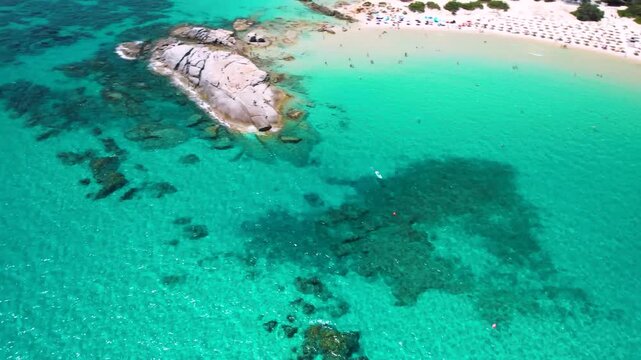 Sardinia Costa Rei Scoglio di Peppino Beach Aerial 4K Video Drone Flight Over Turquoise Sea with Famous Granite Rock and Surfing Boat European Maldives Tropical Caribbean Style Paradise Italy