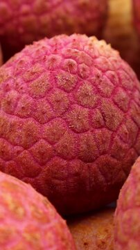 Bright red lychee fruit circle rotation close up, vertical video format