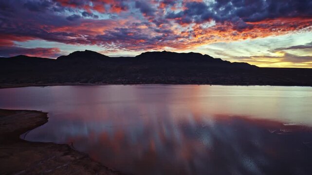 Cinematic drone footage capturing vibrant sunrise colors above Caballo Lake State Park in New Mexico.