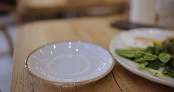 Person drinking delicious cup of flat white coffee near plate of healthy food