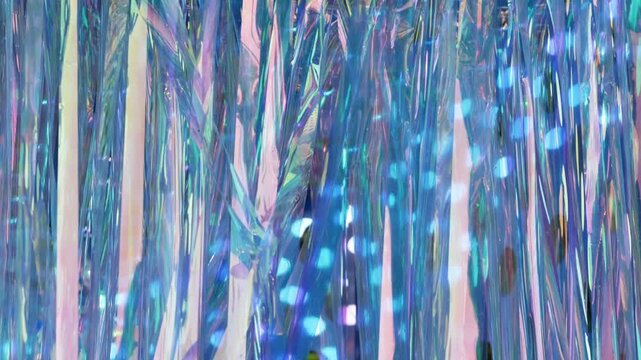 Iridescent holographic tinsel curtain with shimmering blue and pink light reflections