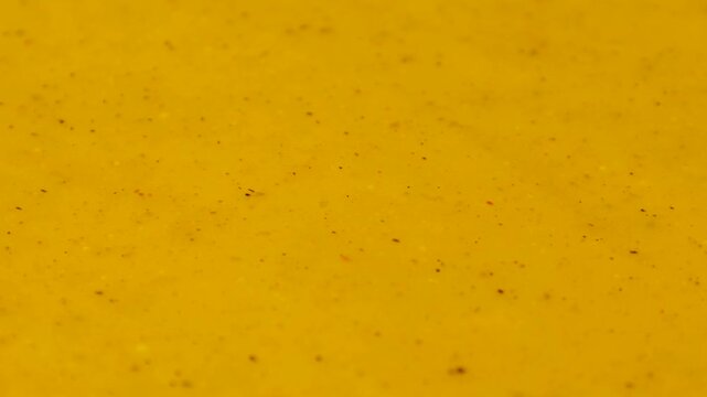 Yellow curry sauce texture circle rotation close up