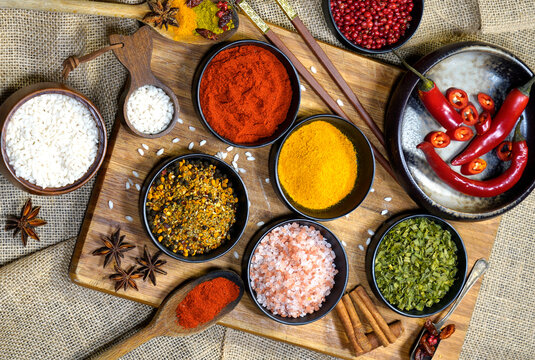 Natura morta. Still life riso con spezie colorate in polvere e grani su vassoio nero e yuta