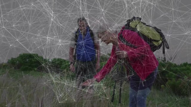 Mature hikers examining grasses in grassland, with animated health chart and backpack icon floating