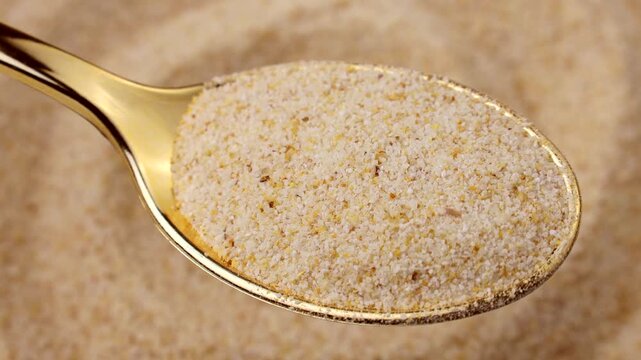 Dried granulated garlic in a spoon with background circle rotation close up