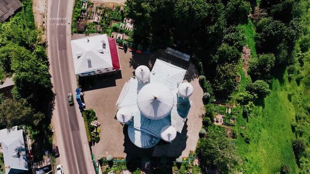 A beautiful tall white Orthodox church with blue domes and golden crosses. Aerial photography