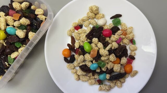Nuts, dried fruits, candied fruits in container and on dish