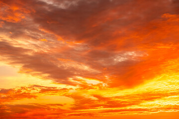 Obraz premium Beautiful sunset sky with golden sun rays and clouds. Dramatic orange and blue morning heaven background. Natural sunrise light effect in summer