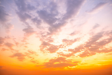 Fototapeta premium Beautiful sunset sky with golden sun rays and clouds. Dramatic orange and blue morning heaven background. Natural sunrise light effect in summer