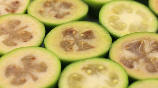 Green feijoa fruit slices circle rotation close up
