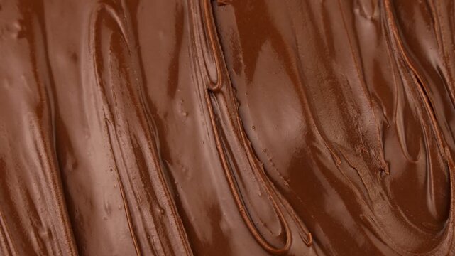 Brown creamy melted milk chocolate spread texture circle rotation close up
