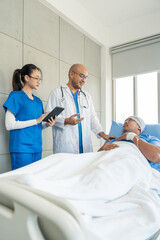 Obraz premium Doctor team visiting man cancer patient with care and compassion in hospital room. Oncology support medical consultation healthcare and hope. Doctor reporting medical test results to the patient