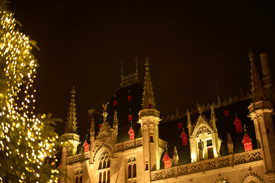 A beautifully lit castle with red windows and ornate spires against a dark night sky. Zurich, Switzerland