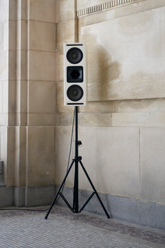 Speaker on a tripod stand in an elegant stone building with intricate architectural details. Brussels, Belgium