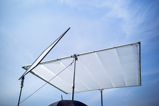 Large light diffusers set up against a clear blue sky on a sunny day. Germany