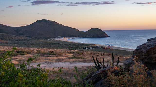 Coastal landscape at sunrise with mountains, beach, and calm sea view. Todos Santos, Baja California, Mexico