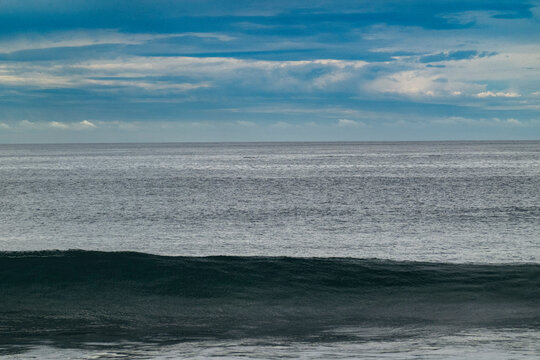 Calm ocean waves under a blue cloudy sky create a serene and peaceful seascape. Gulf of California, Mexico