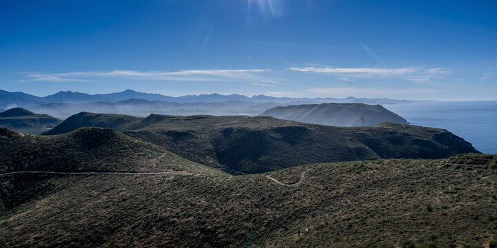 Vast mountainous landscape under a clear blue sky with distant ocean views. Mirador Punta Lobas, Baja California Sur, Mexico