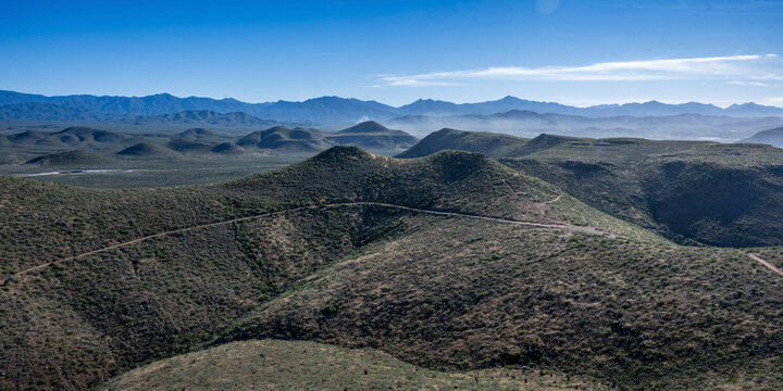 Rolling desert hills under a clear blue sky with distant mountain range views. Mirador Punta Lobas, Baja California Sur, Mexico