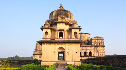 Obraz premium Golden hour view of historic Royal cenotaphs of Orchha with dramatic clouds and soft light, Madhya Pradesh, India.