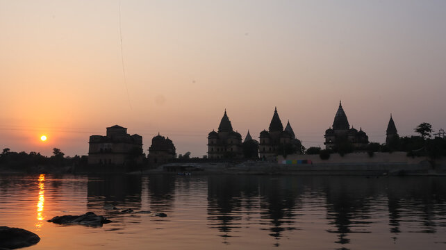 Orchha cenotaphs Silhouette in warm sunset light along Betwa River, Madhya Pradesh, India.