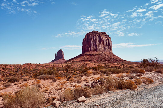 Majestic rock formations under a bright blue sky in a vast desert landscape. Monument Valley, Arizona, USA