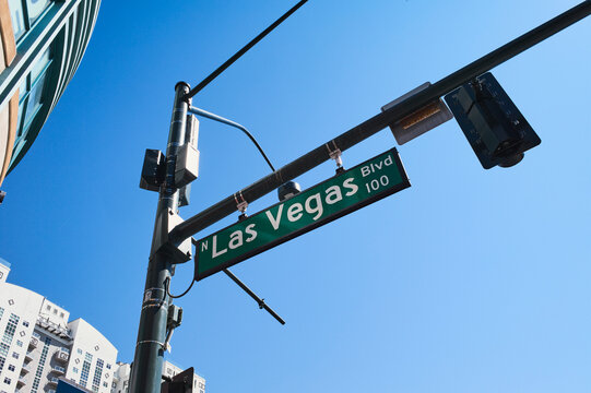 Las Vegas Boulevard street sign against a clear blue sky with a city building in the background. Las Vegas, Nevada, USA