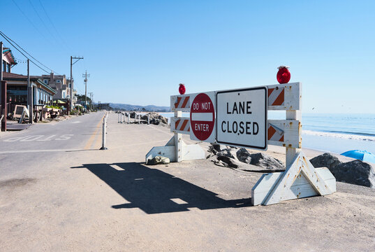 Lane closed sign on a coastal road by the ocean under a clear blue sky. Half Moon Bay, California, USA