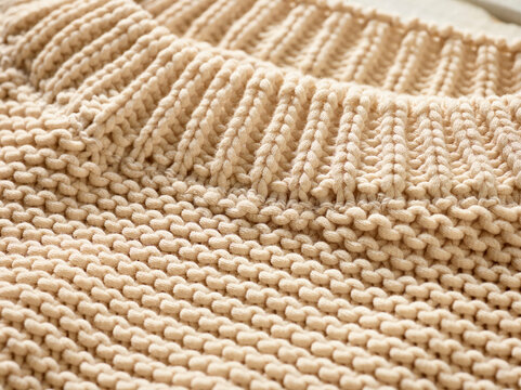 Close-up of a beige knitted fabric with ribbed and plain stitch patterns. Germany