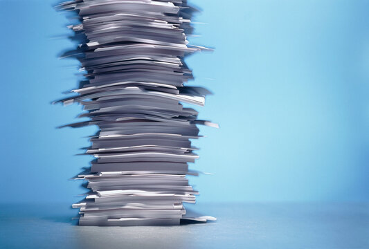 Tower of stacked papers on a smooth blue surface with a blue background. Germany