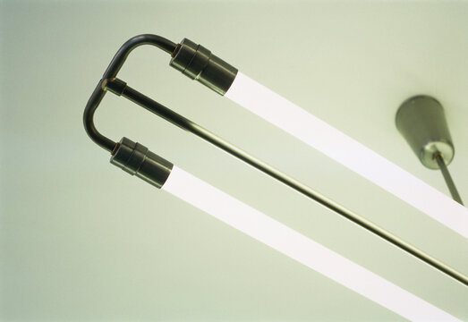 Two parallel fluorescent light tubes on a ceiling fixture against a light-colored background   Germany
