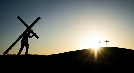 Silhouette of a man carrying a large cross up a hill at sunset with two crosses in the background