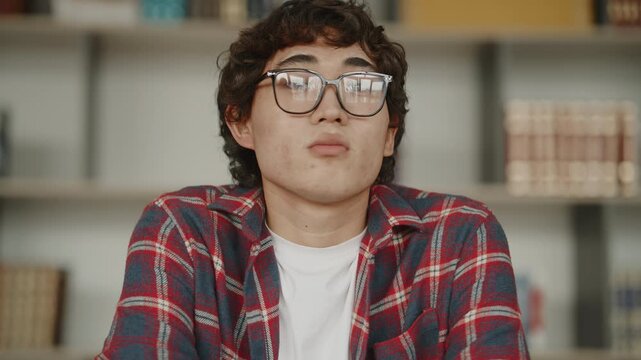 Bored asian student feeling tired in library