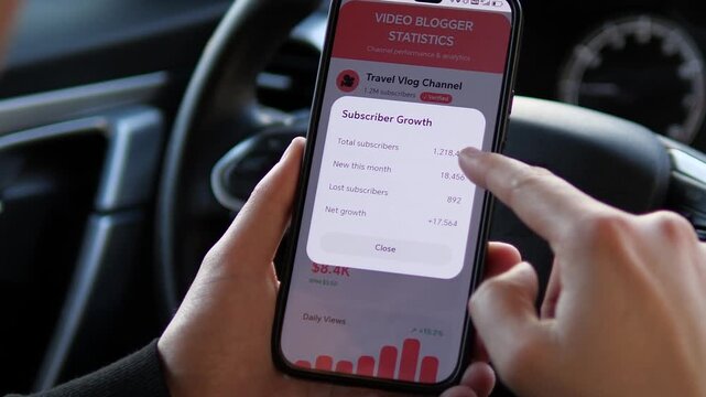Influencer Checking Travel Vlog Channel Analytics in Car. Close-up of influencer checking subscriber growth and estimated revenue on a mobile app dashboard. Professional analytics for digital