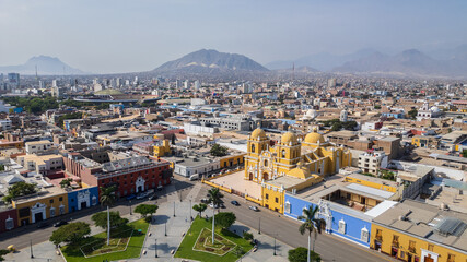 Fototapeta premium High-resolution aerial drone view of the Plaza de Armas de Trujillo in Trujillo, showcasing colonial architecture, colorful buildings, and the historic city center surrounded by palm trees