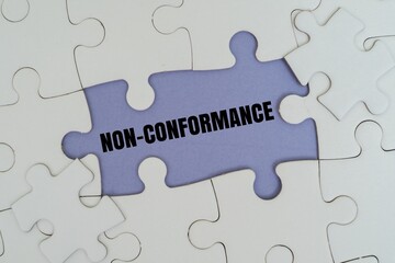 Fototapeta premium NON-CONFORMANCE word alphabet ketters on puzzle. A metaphor for quality control failure, process errors, and deviation from industrial standards or ISO regulations