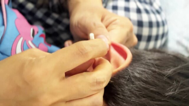 INCHEON, SOUTH KOREA - MARCH 17, 2026: Close-up of a Mother's Hand Carefully Cleaning Her Child's Ear with a Cotton Swab