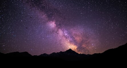 Fototapeta premium Mystical purple night sky featuring the Milky Way over serene mountain silhouettes with space for branding