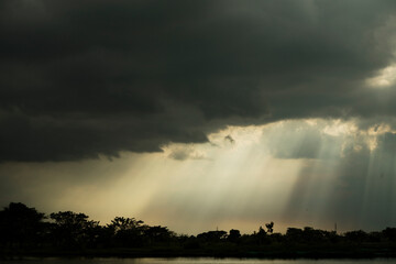 Fototapeta premium Moody Sky with Sun Rays Breaking Through Clouds