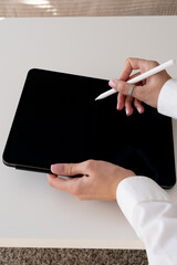 Female hands drawing on a digital tablet with a stylus, creative digital art and technology concept, modern workspace, white background © Juli