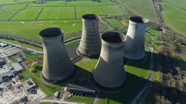 Aerial view of the stark, monumental cooling towers standing in striking contrast to the surrounding verdant fields, a relic of industry against nature's canvas, Retford, United Kingdom.