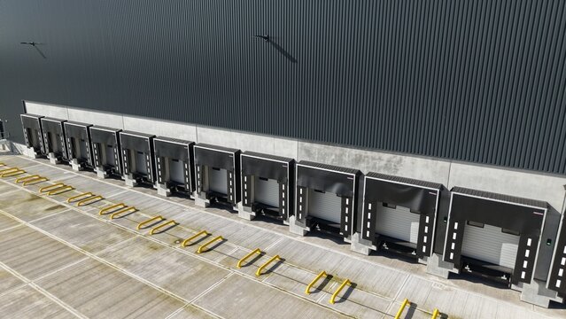 Aerial view of rhythmic loading bays cast stark shadows on concrete, the industrial facade a study in monochrome, Doncaster, United Kingdom.
